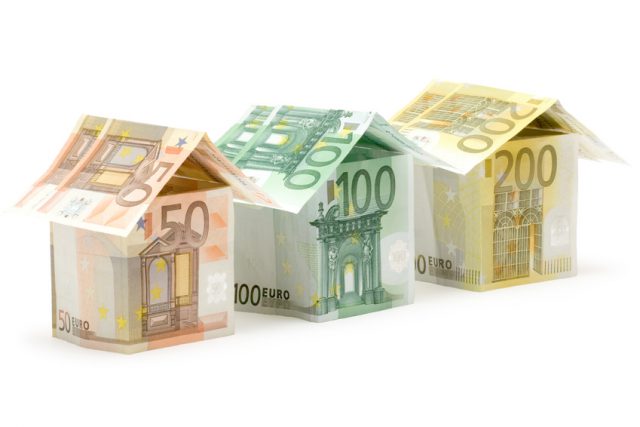 Three colorful houses built of different euro bills. Isolated on a white background.