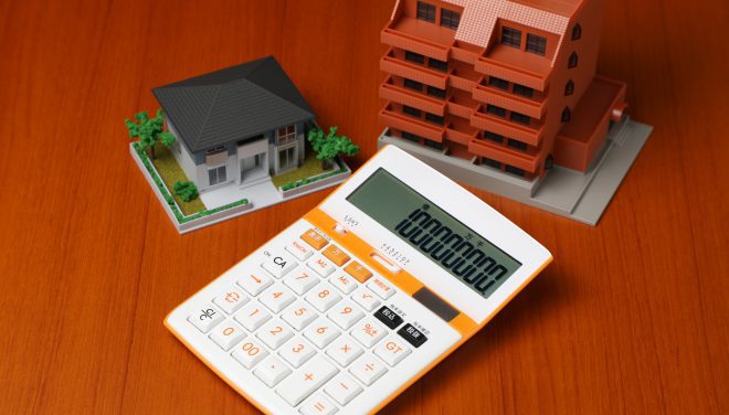 calculator and house building miniature models on the table